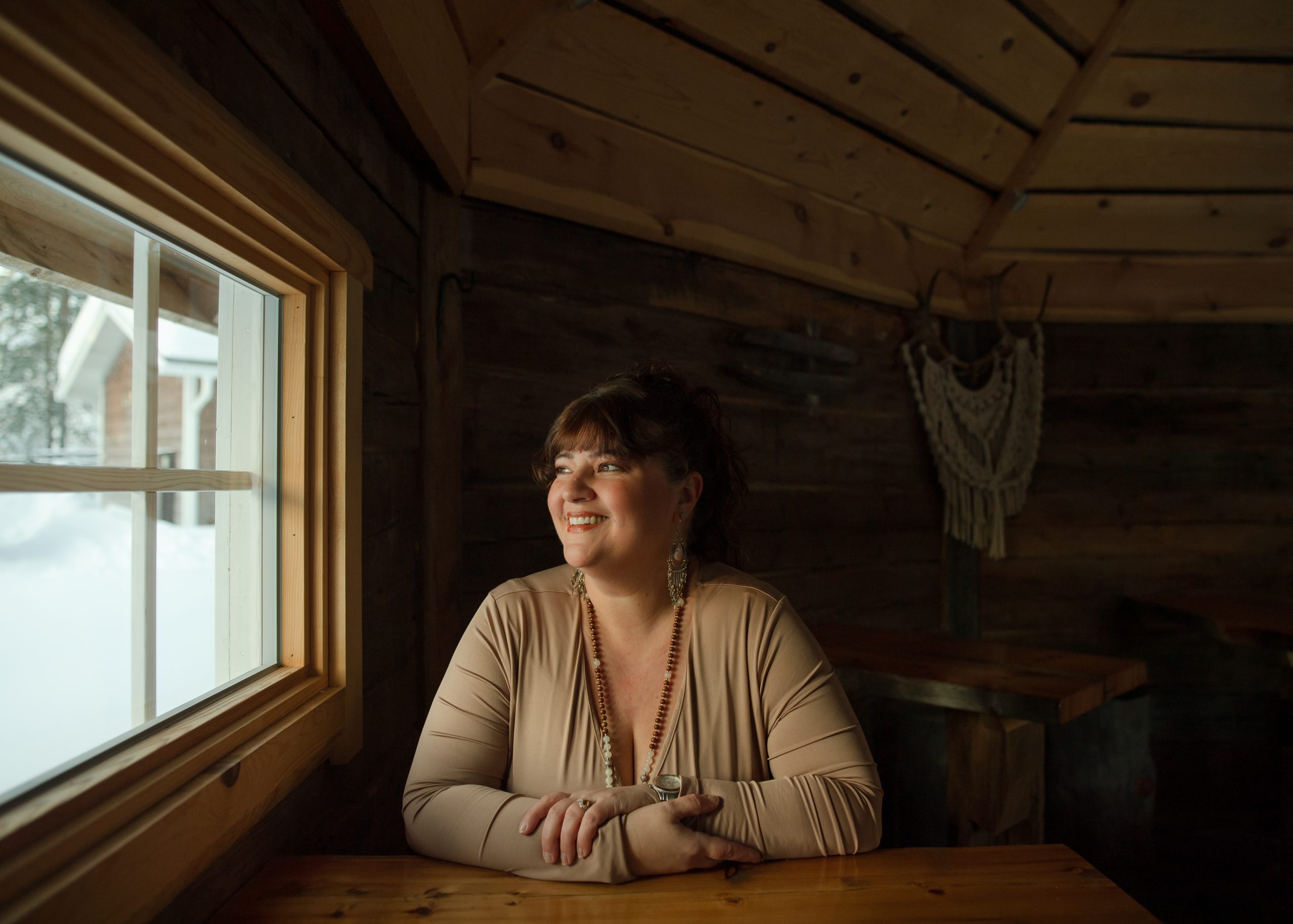 Helena Karchere in hut in Finland Helena Karchere coach looking centered and joyful on retreat